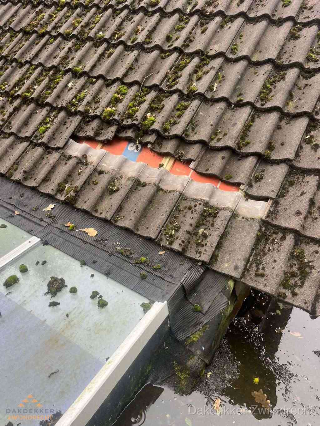 Beschadigd pannendak met ontbrekende dakpannen voor reparatie in Zwijndrecht