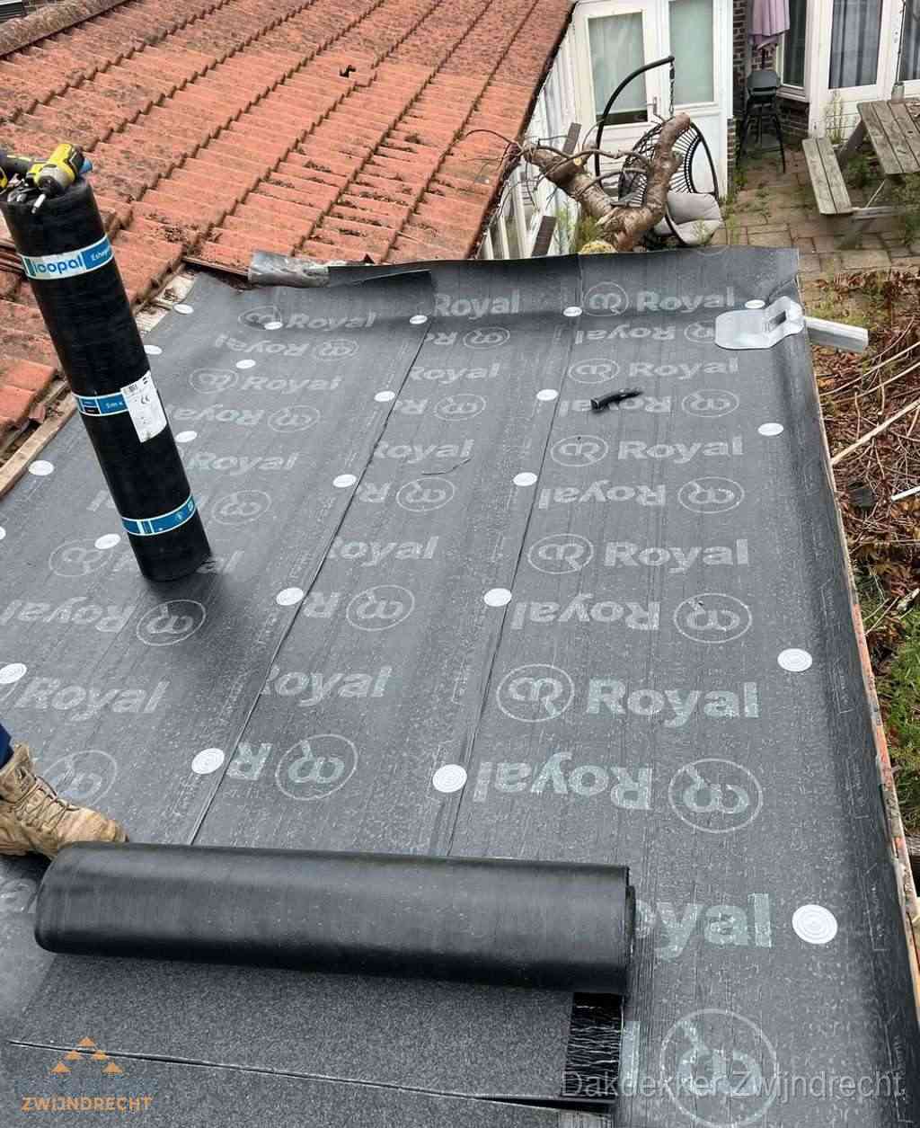 Plat dak met nieuwe bitumen dakbedekking en brandgereedschap in Zwijndrecht