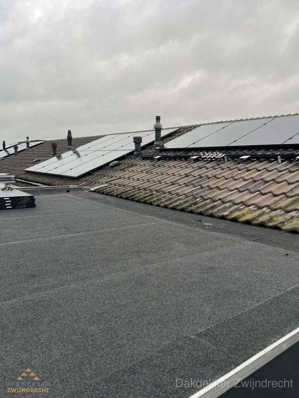 Plat dak inspectie met bitumen bedekking naast schuin pannendak in Zwijndrecht