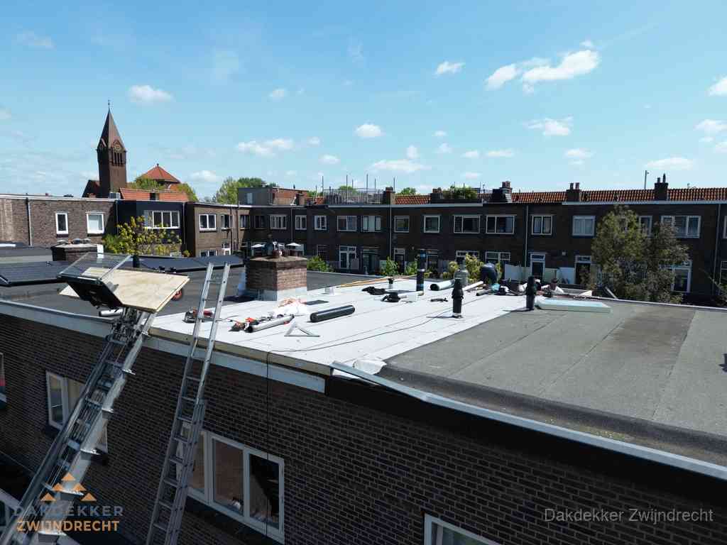 Dakdekkers aan het werk op plat dak in Zwijndrecht