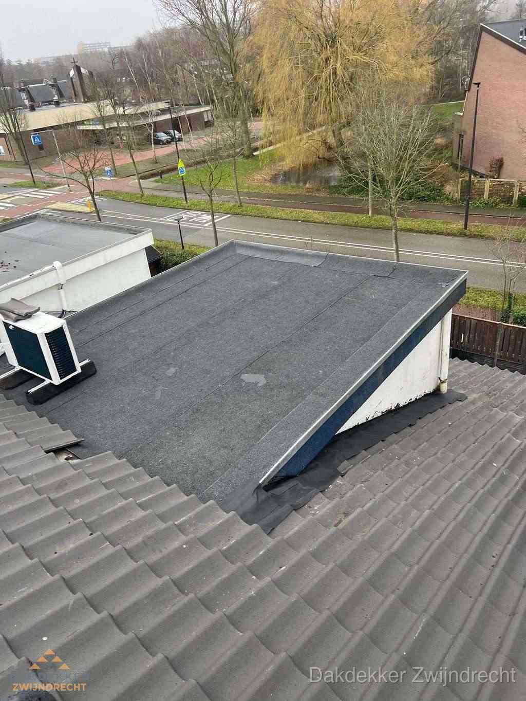 Plat dak met bitumen dakbedekking naast schuin pannendak in Zwijndrecht