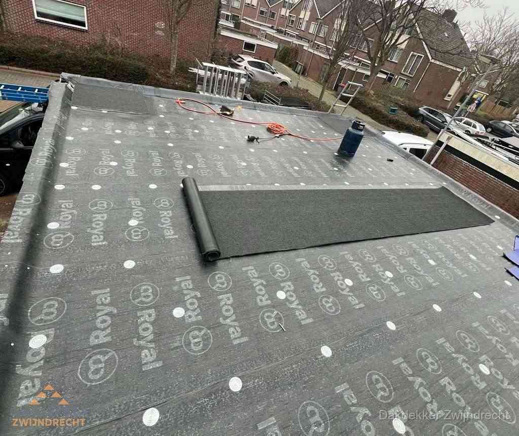 Dakdekker aan het werk met gasbrander op plat bitumen dak in Zwijndrecht