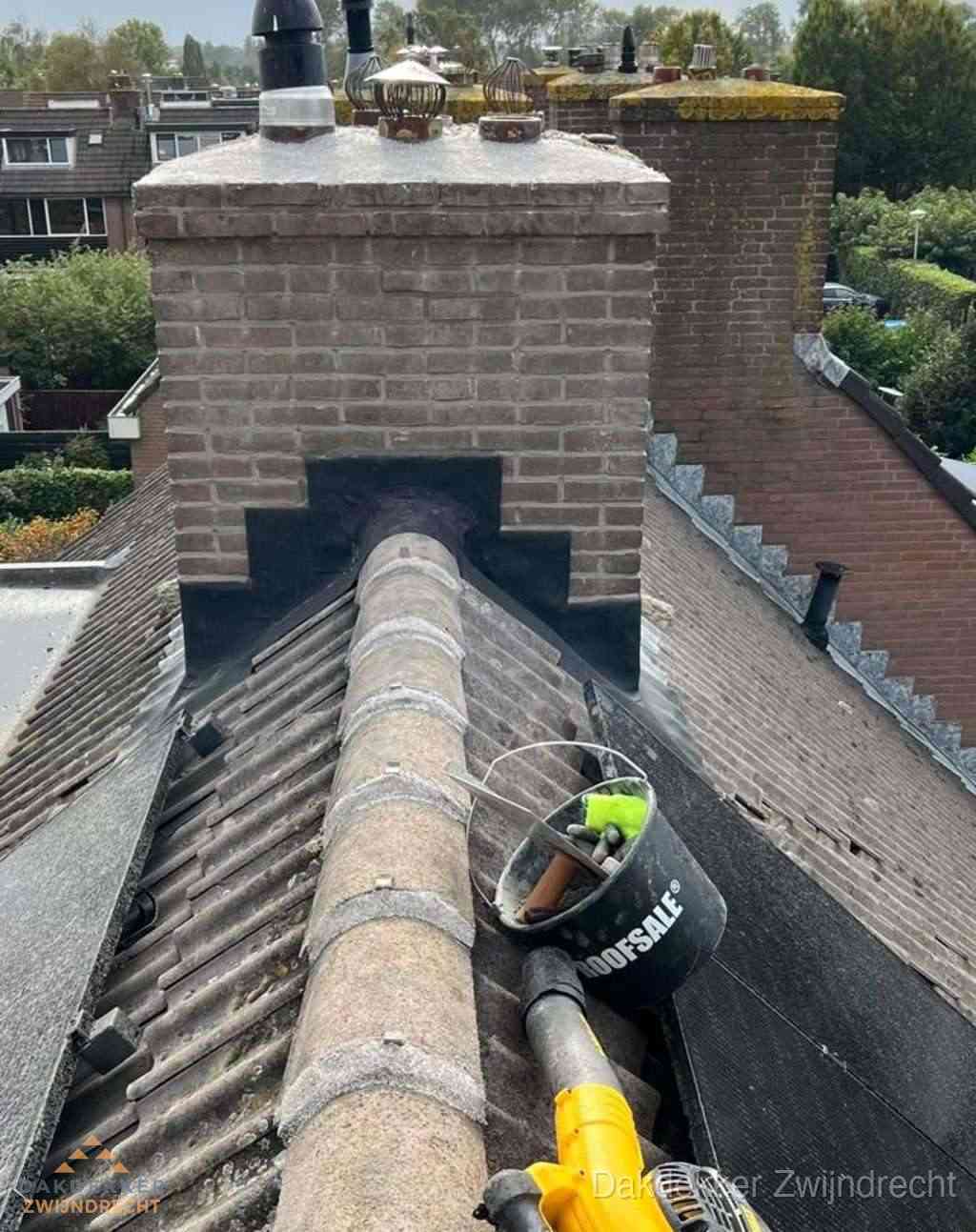 Dakdekker repareert bitumen dakleer bij dakdoorvoer in Zwijndrecht